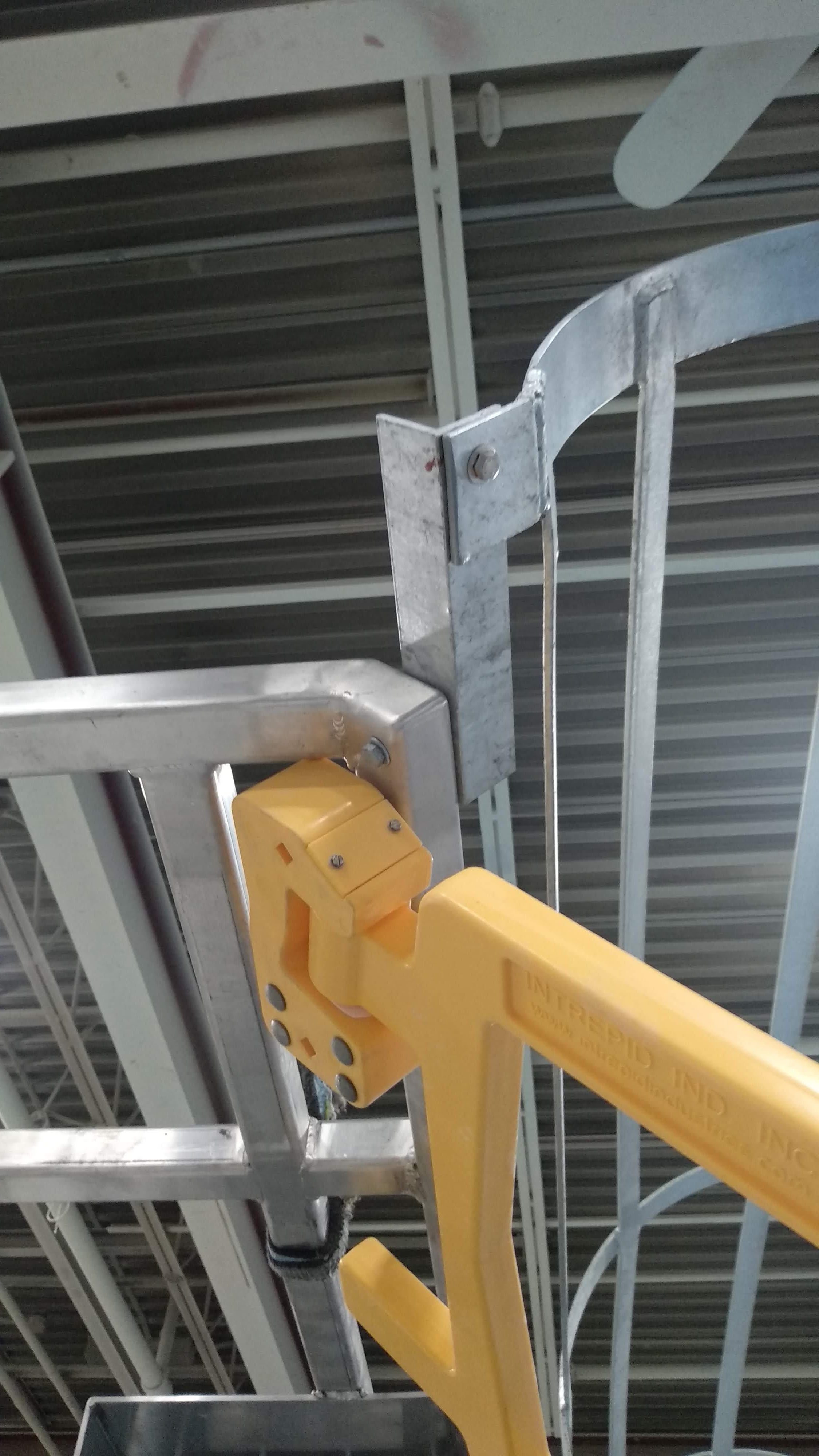 Close-up of the universal reversible hinge on an Intrepid UDG safety gate mounted to a galvanized guardrail post