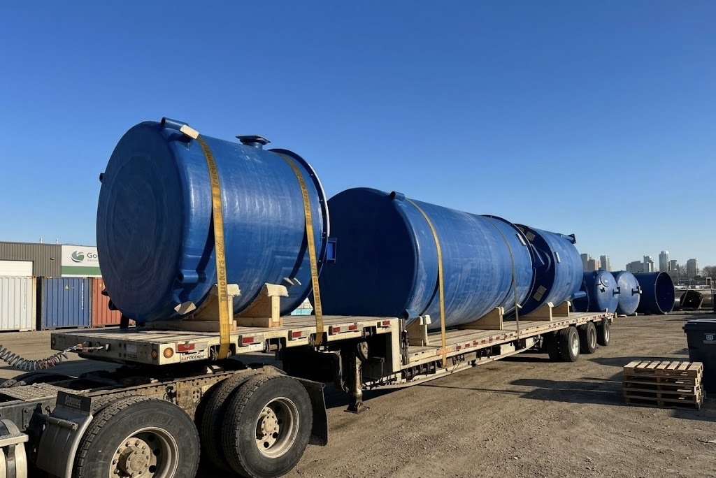 Blue FRP storage tanks on flatbed trailer